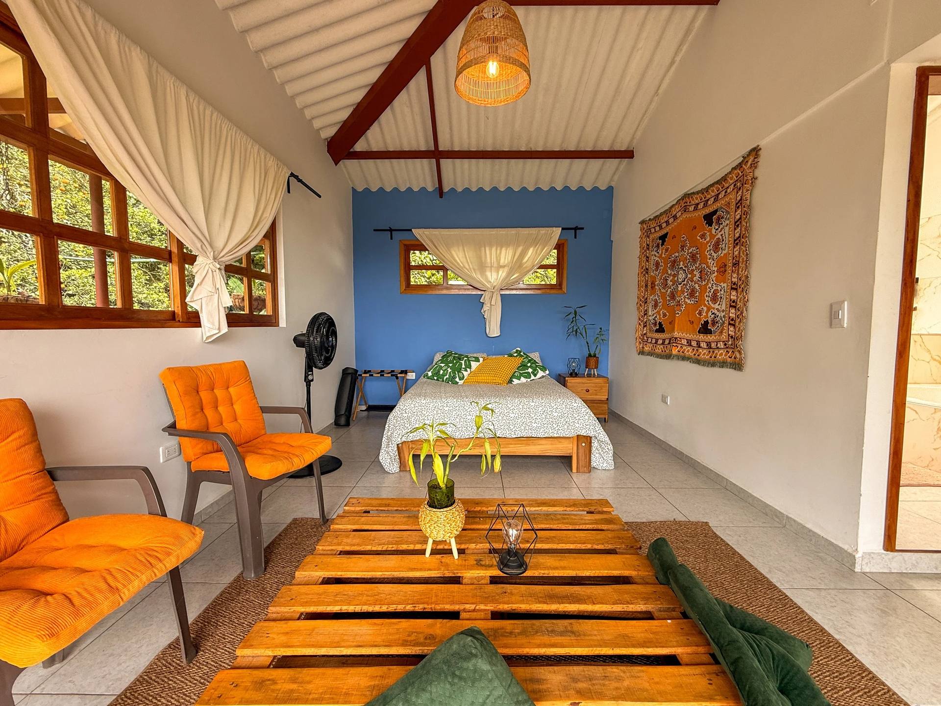 Interior of the Queen Suite with balcony access and greenery at El Nido Andino, La Mesa, Cundinamarca