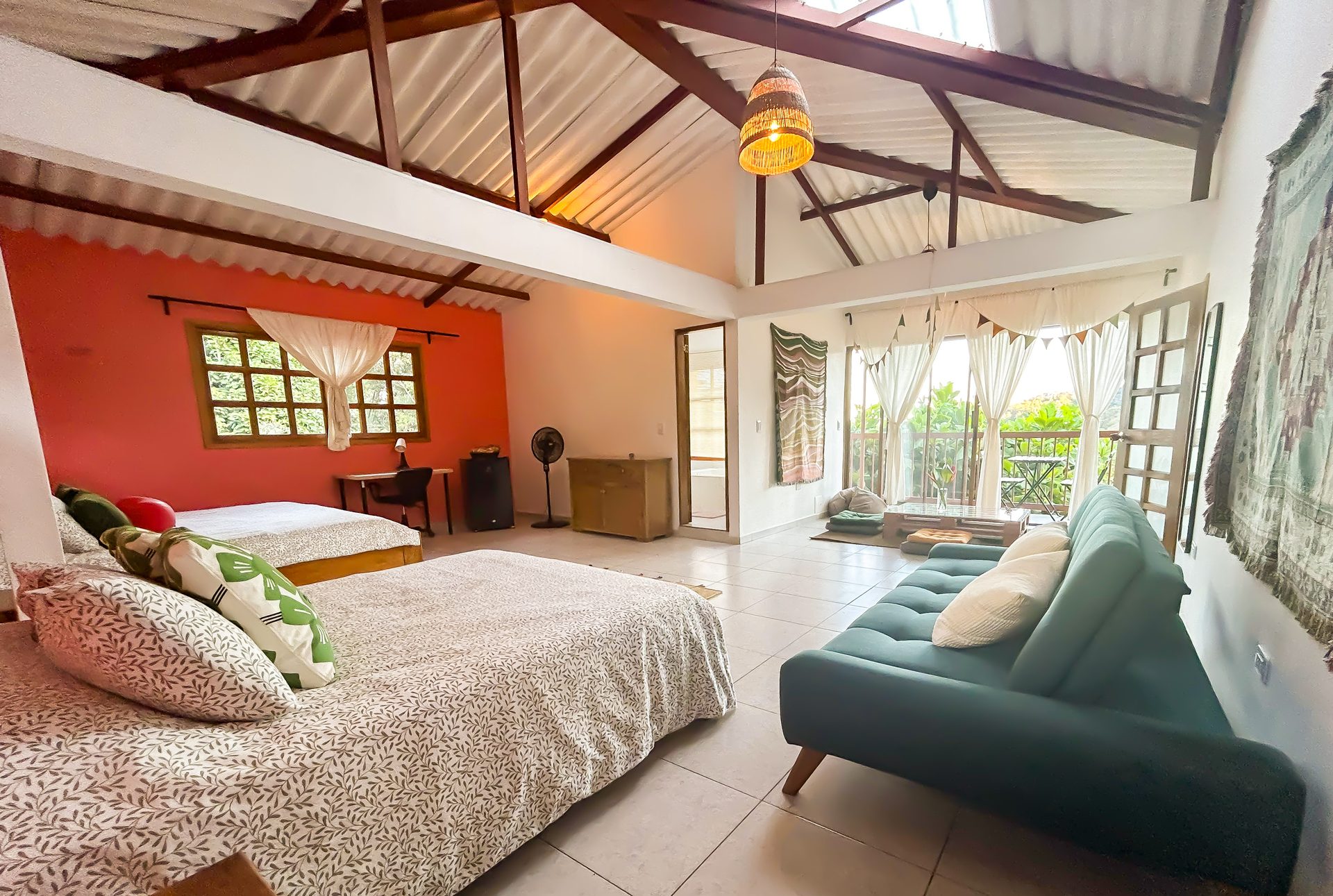 Cama y sofá de la Suite King con puertas al balcón en El Nido Andino, La Mesa Cundinamarca