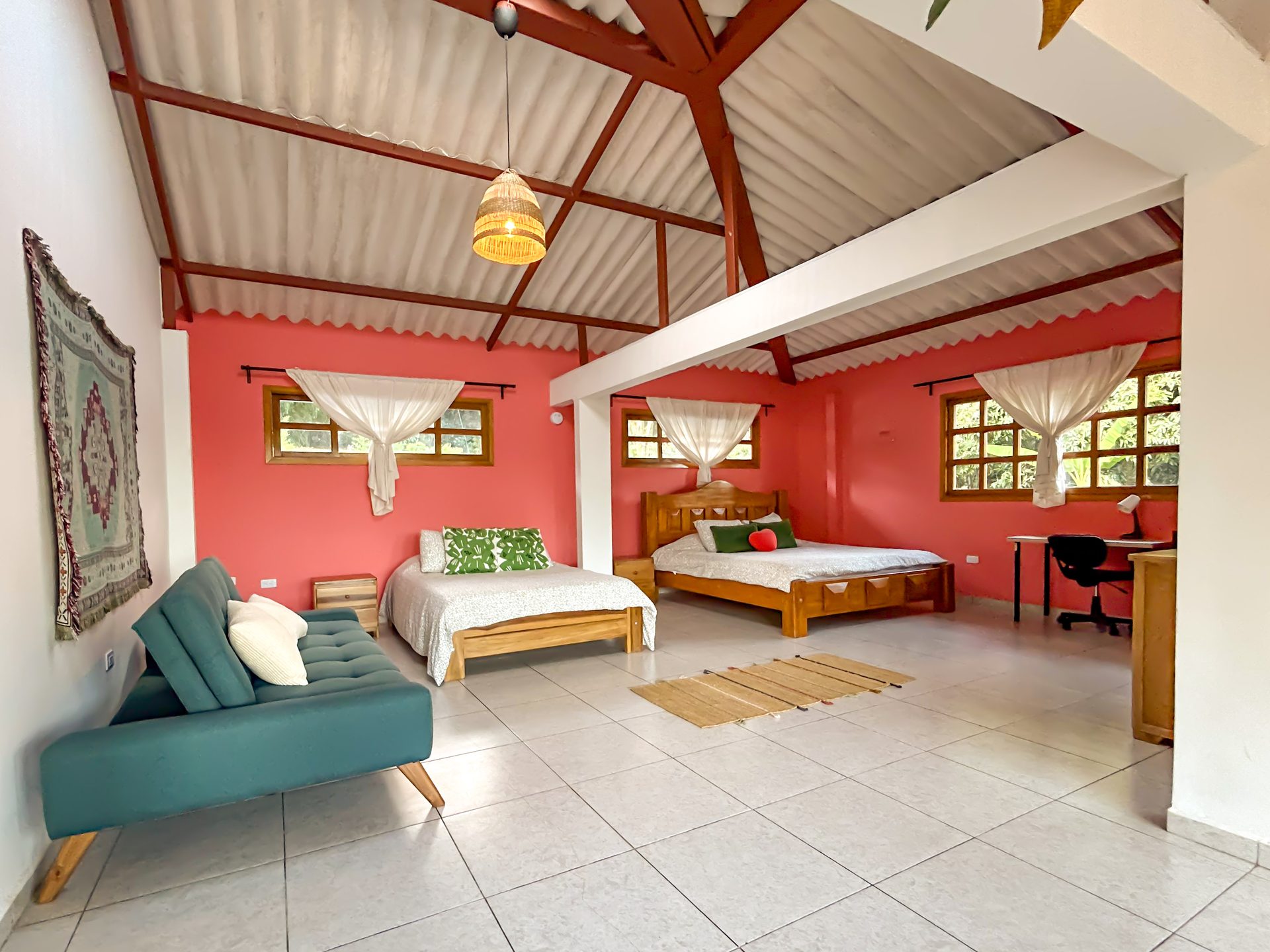 Interior amplio de la Suite King con cama King, cama Queen y sofá en El Nido Andino, La Mesa